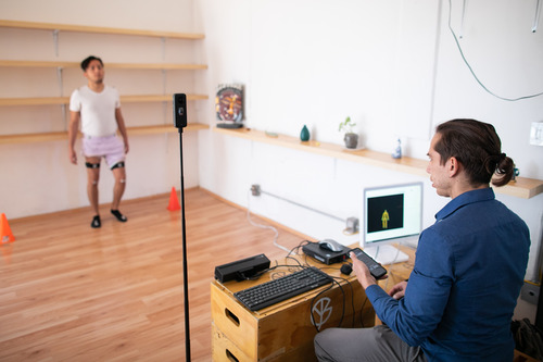 Photo of Adrian assisting a patient using his technology.