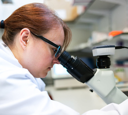 A woman looking through a telescope.