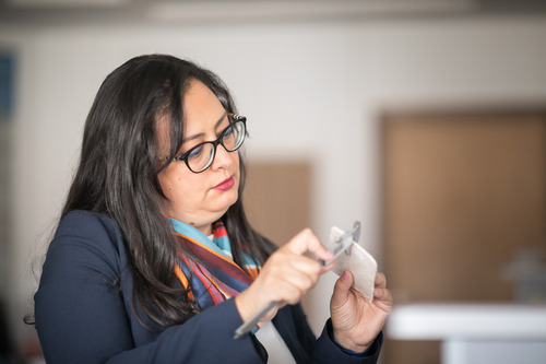 Photo of Irene studying the material used in the packaging.