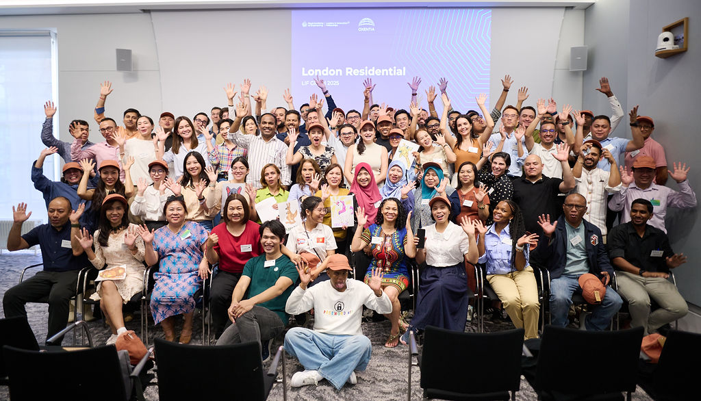 LIF Global 2025 awardees stand in a large group on a stage, smiling towards the camera.