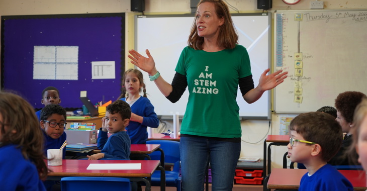 Alex stands in a classroom