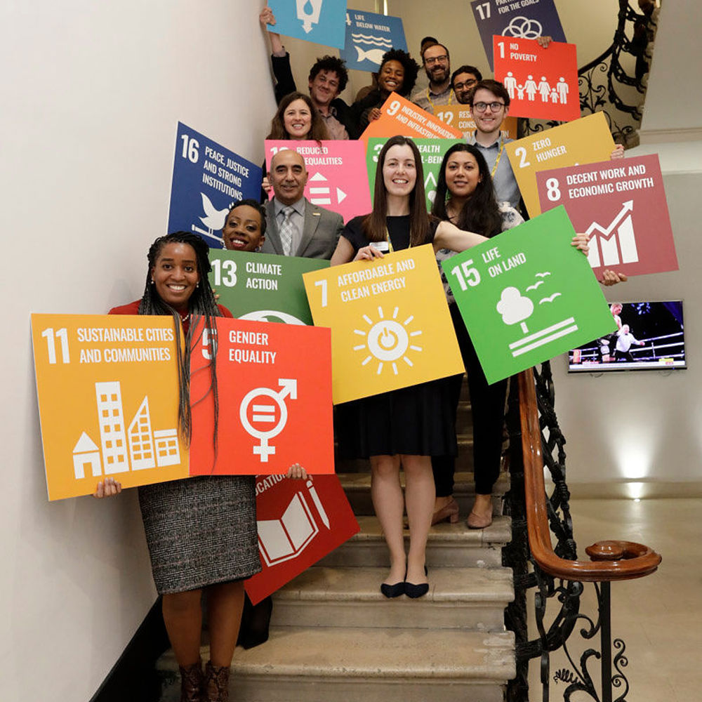 academy staff posing with SDG sign in Prince Philip House