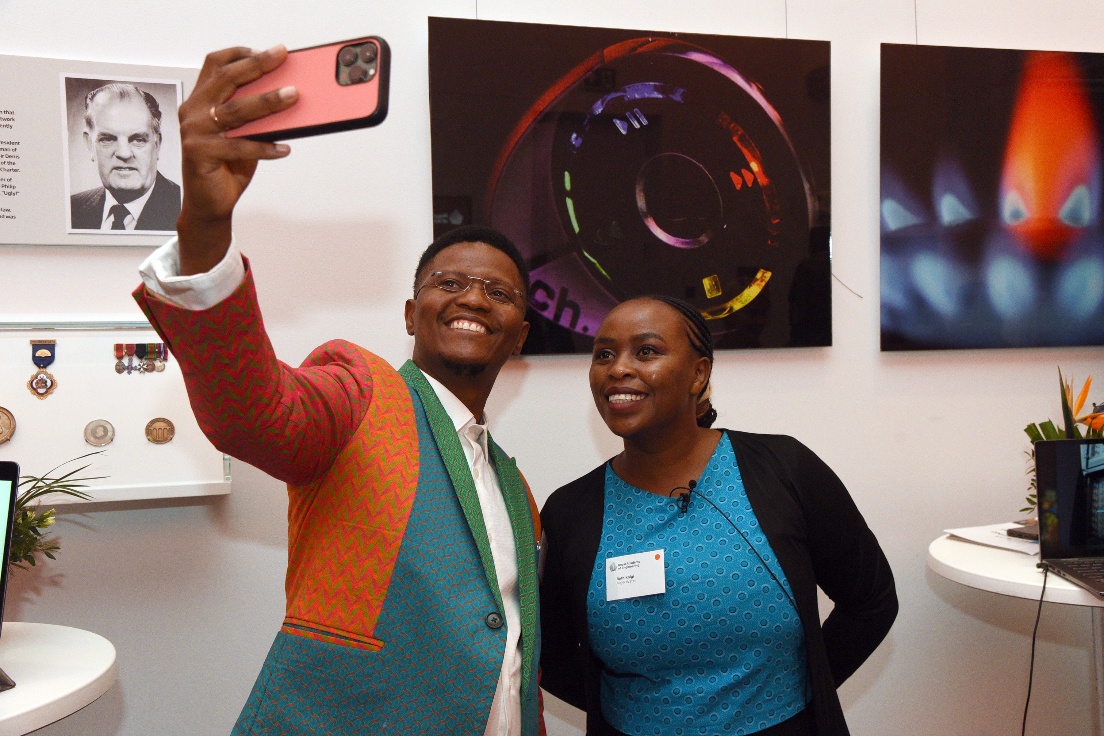 Two people pose for a photo in the Royal Academy of Engineering building.