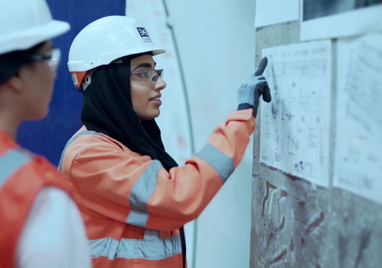 Engineers in hard hats looking at a chart